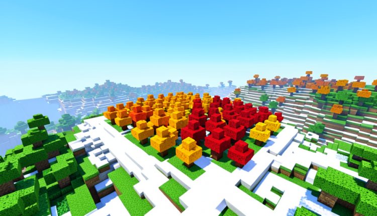 A blocky voxel landscape seen from a hilltop with a patch of bright red, orange and yellow cube trees standing out among green and snowy terrain
